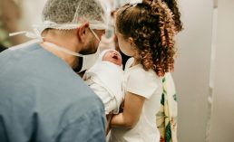 man and child holding baby